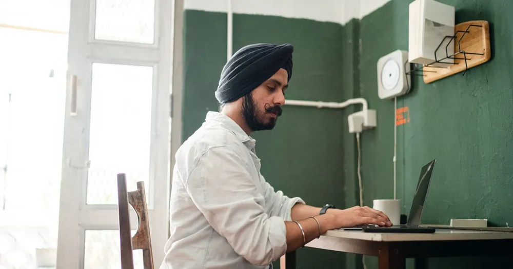 A focused South Asian professional working on a laptop — representing Indian entrepreneurs navigating Canada's new business immigration pathways in 2026 after the Start-Up Visa closure