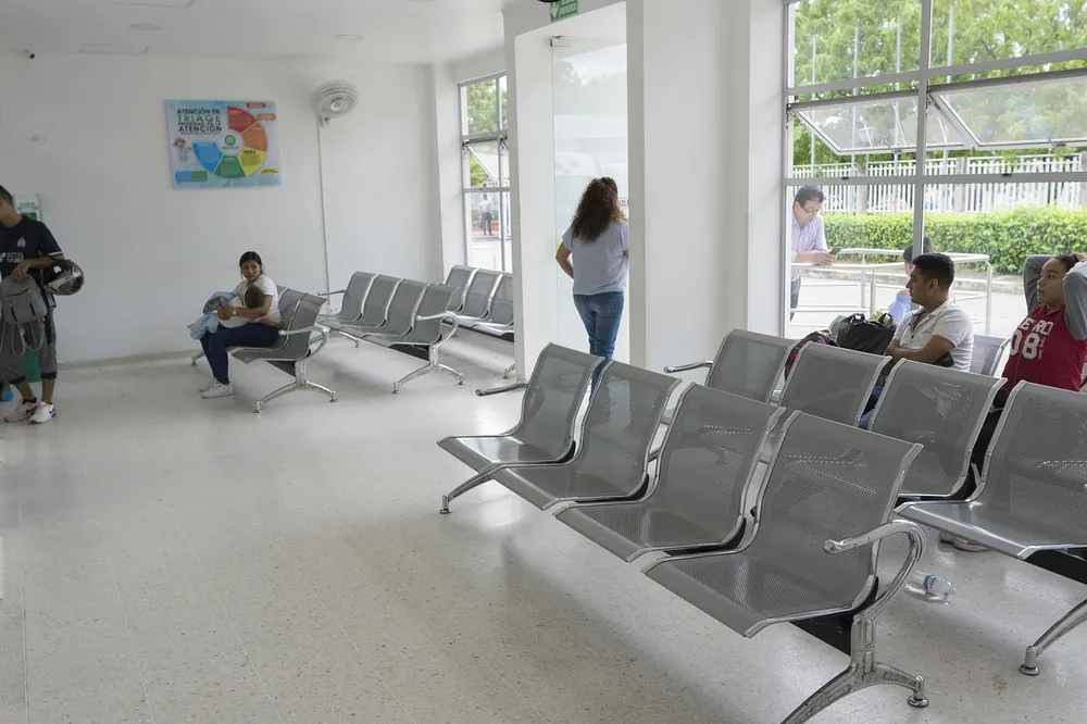 Rows of empty chairs in a hospital or clinic waiting room, representing the wait for non-urgent care in Canada