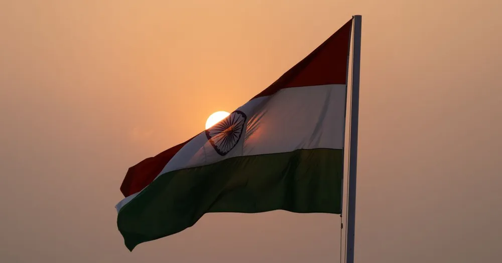 The flag of India waving against a clear sky, representing India's push inside CEPA negotiations for eased business-person mobility to Canada