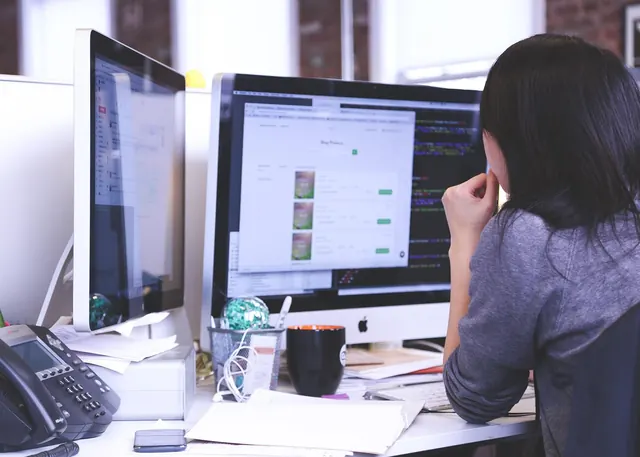 A team of young professionals collaborating around a table with laptops, representing early-career workers navigating a job market reshaped by AI