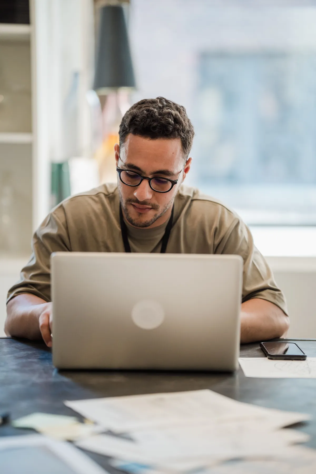 Single entrepreneur at a minimal desk with a glowing laptop screen — the modern solo founder running a team-scale business with AI agents